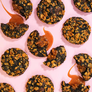 Caramel Cornflake New York Cookie with dark chocolate base, caramel cornflake crunch filling, and crunchy toasted topping.